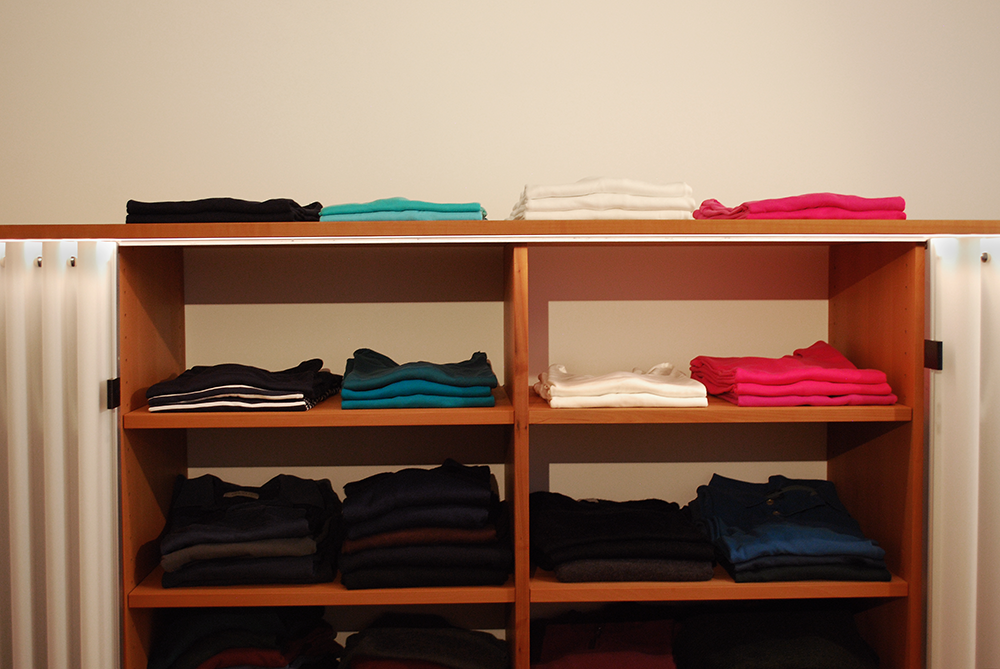 Kleiderschrank mit nach Farben geordneten Kleidern