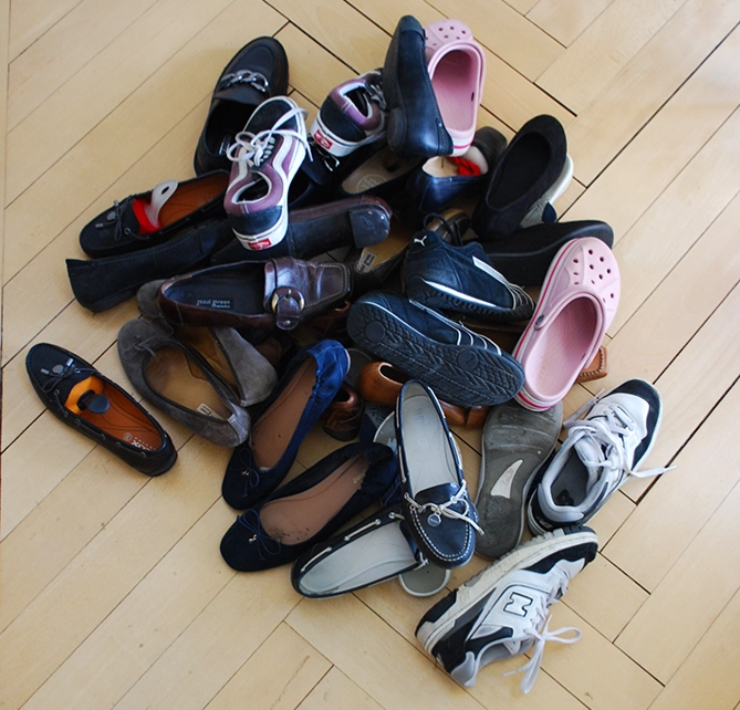Schuhhaufen auf einem Parkettboden. Aufräumservice Zürich