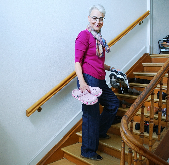 Claudia De Capitani räumt im Treppenhaus Schuhe auf.