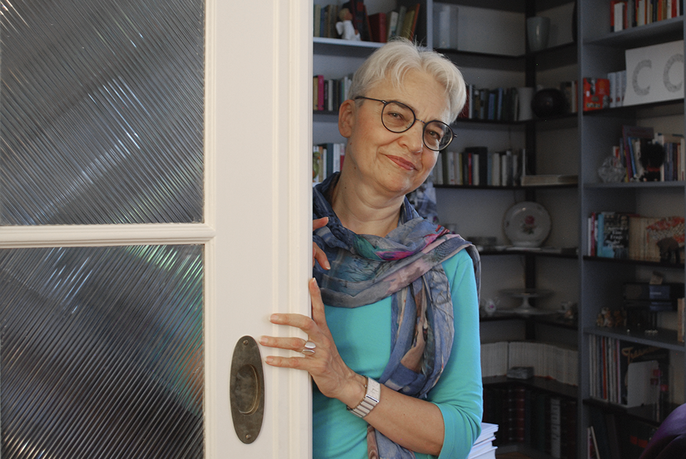 Portrait von Claudia De Capitani im Fokus hinter einer Türe.